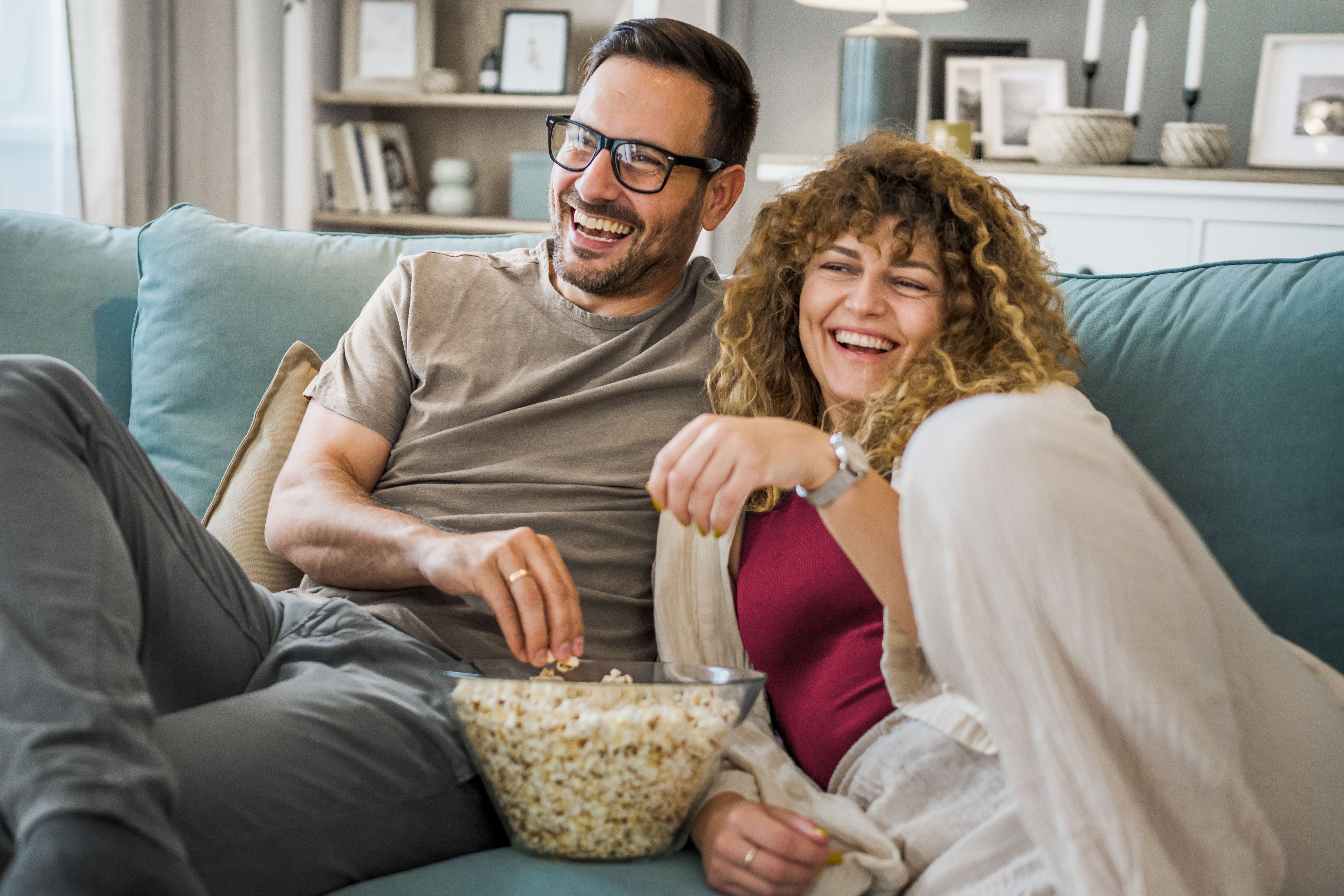 Couple on the sofa with popcorn watching TV