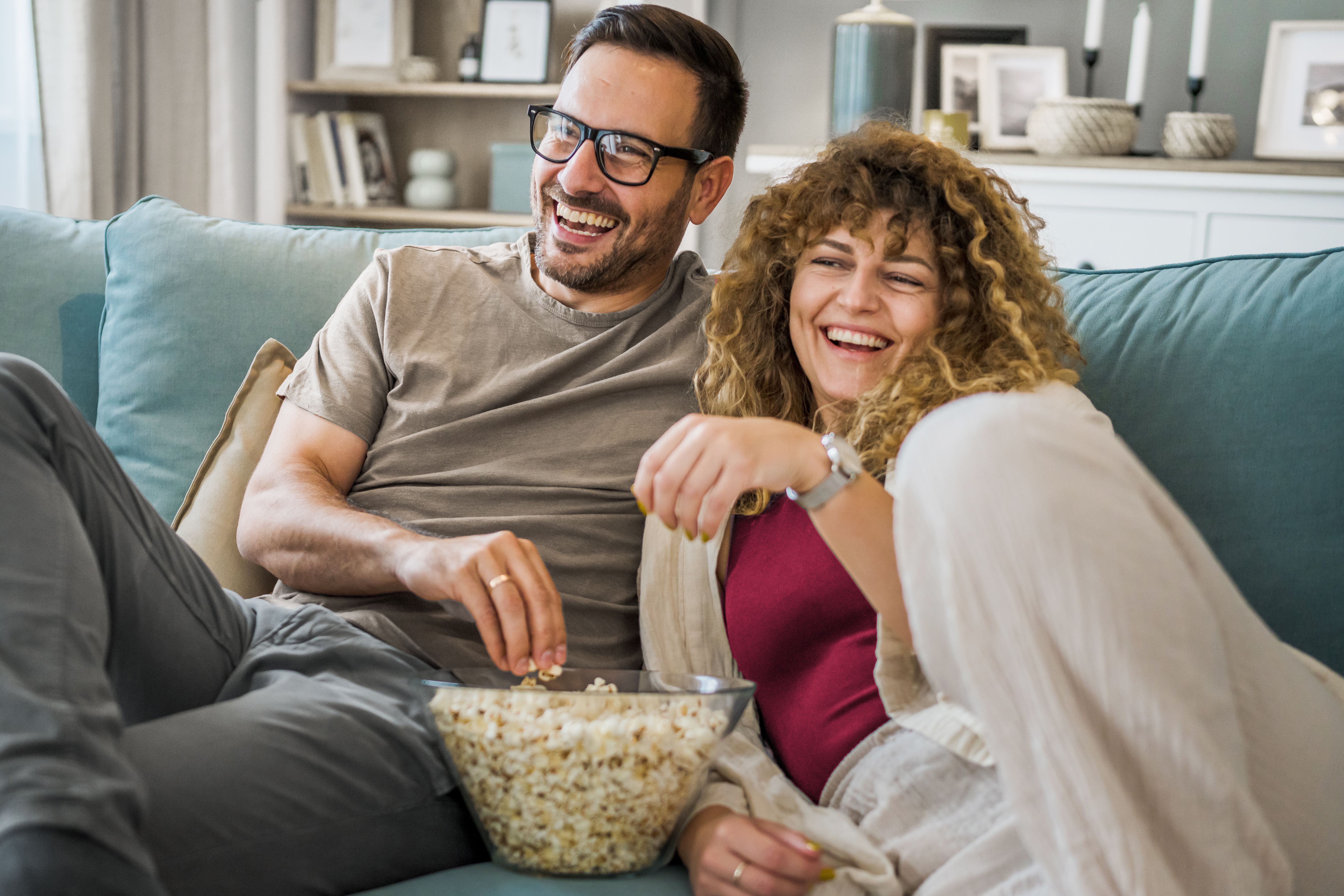Couple sur le canapé avec du pop-corn devant la télévision