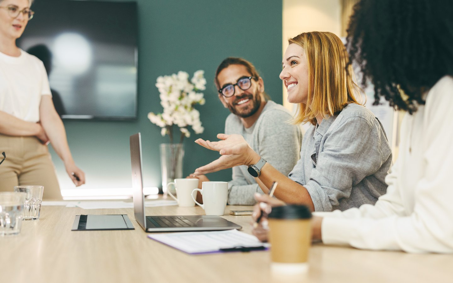 Four happy people around a desk during a conversation