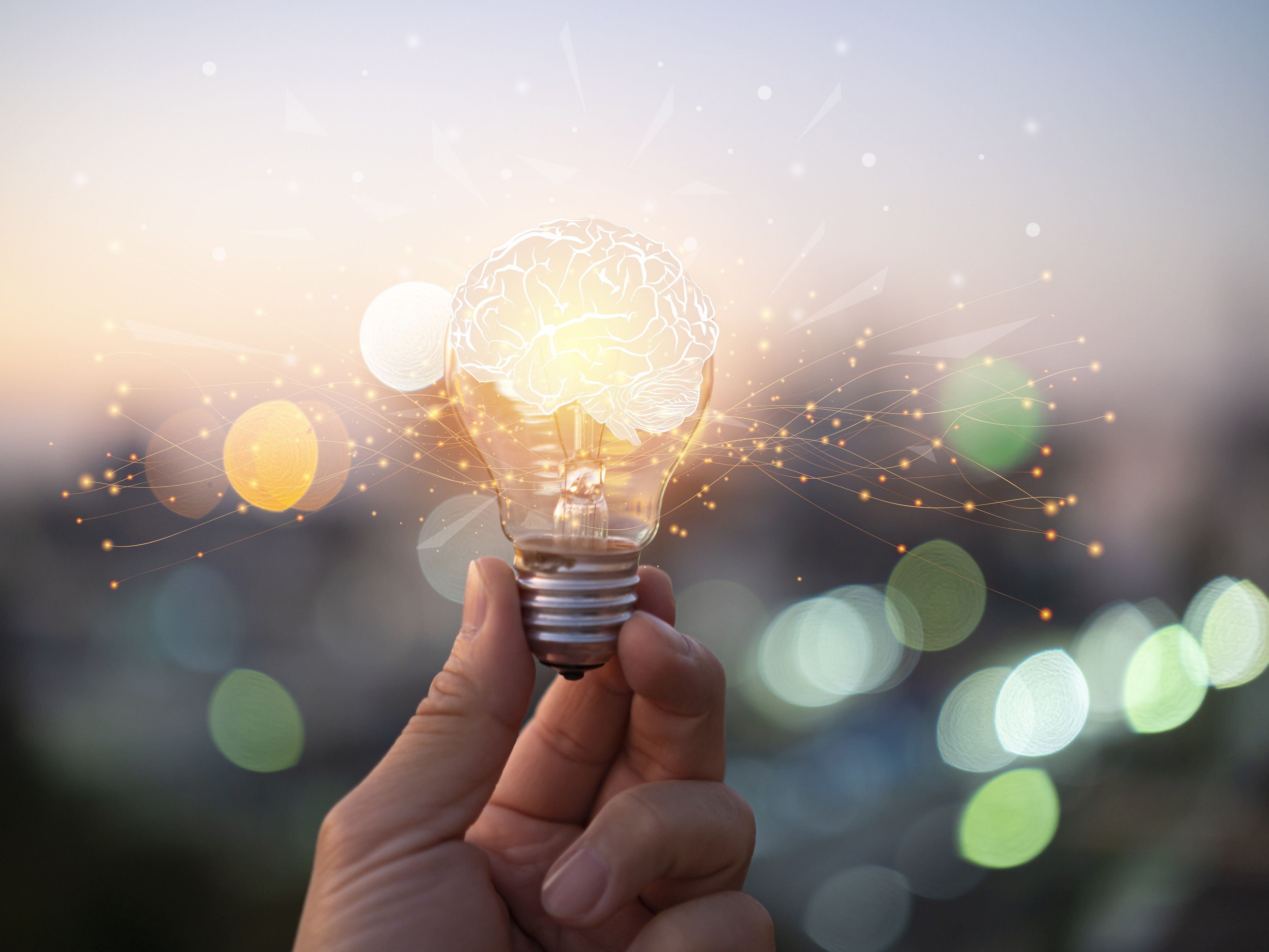hand holding a glowing light bulb as a symbol