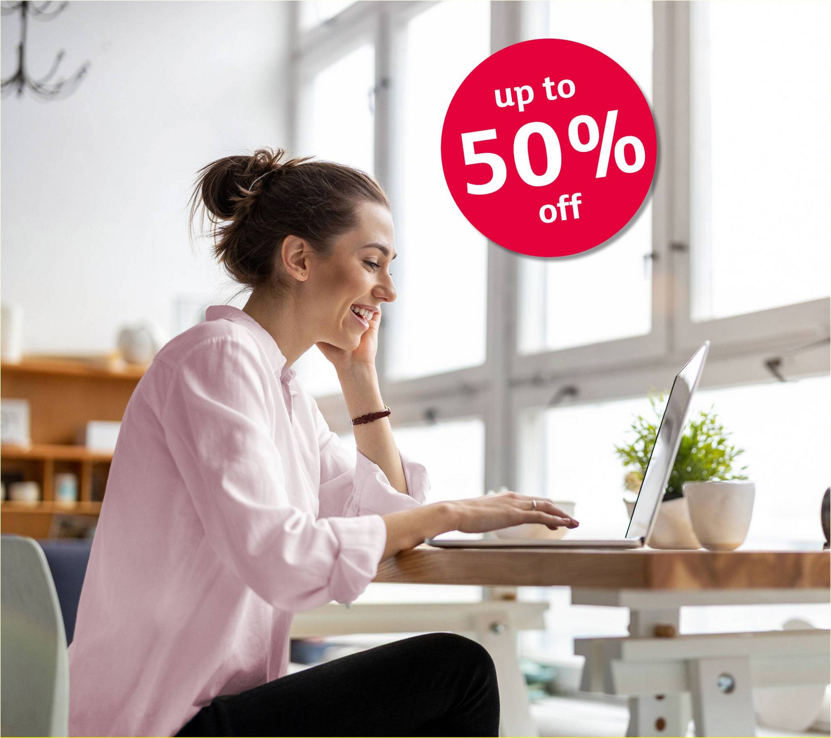 Happy woman in her living room is typing on her laptop