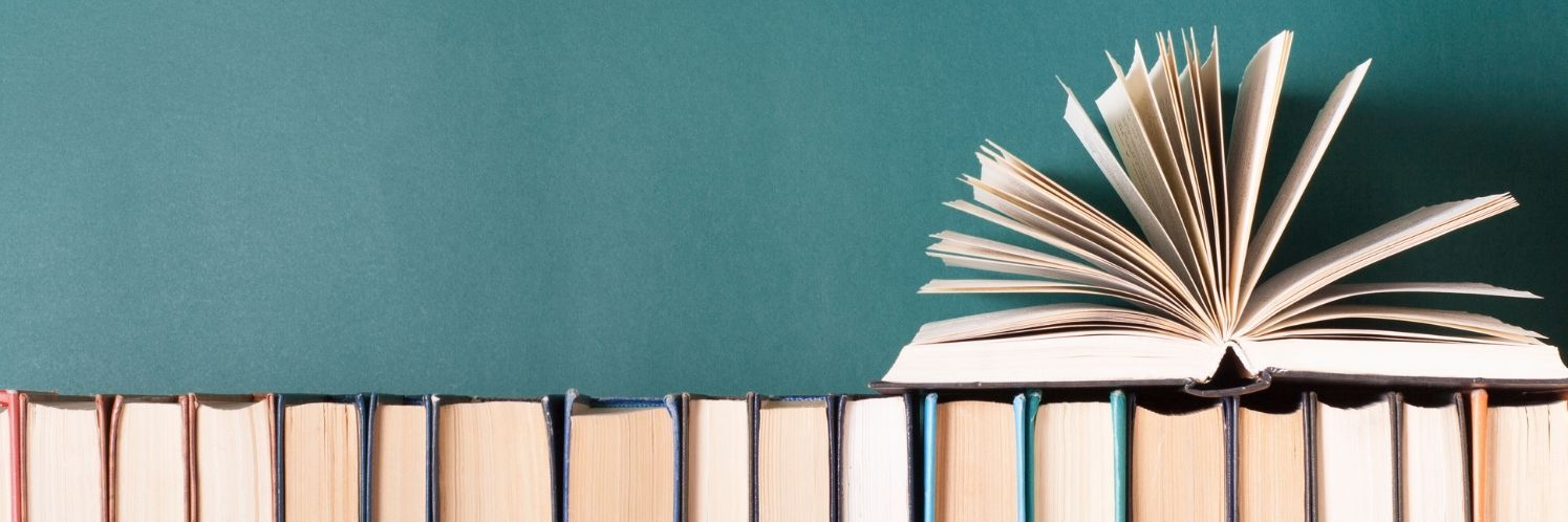 Offenes Buch auf einer Reihe von geschlossenen Büchern – symbolisiert den Unterschied zwischen Website, Webseite und Homepage.