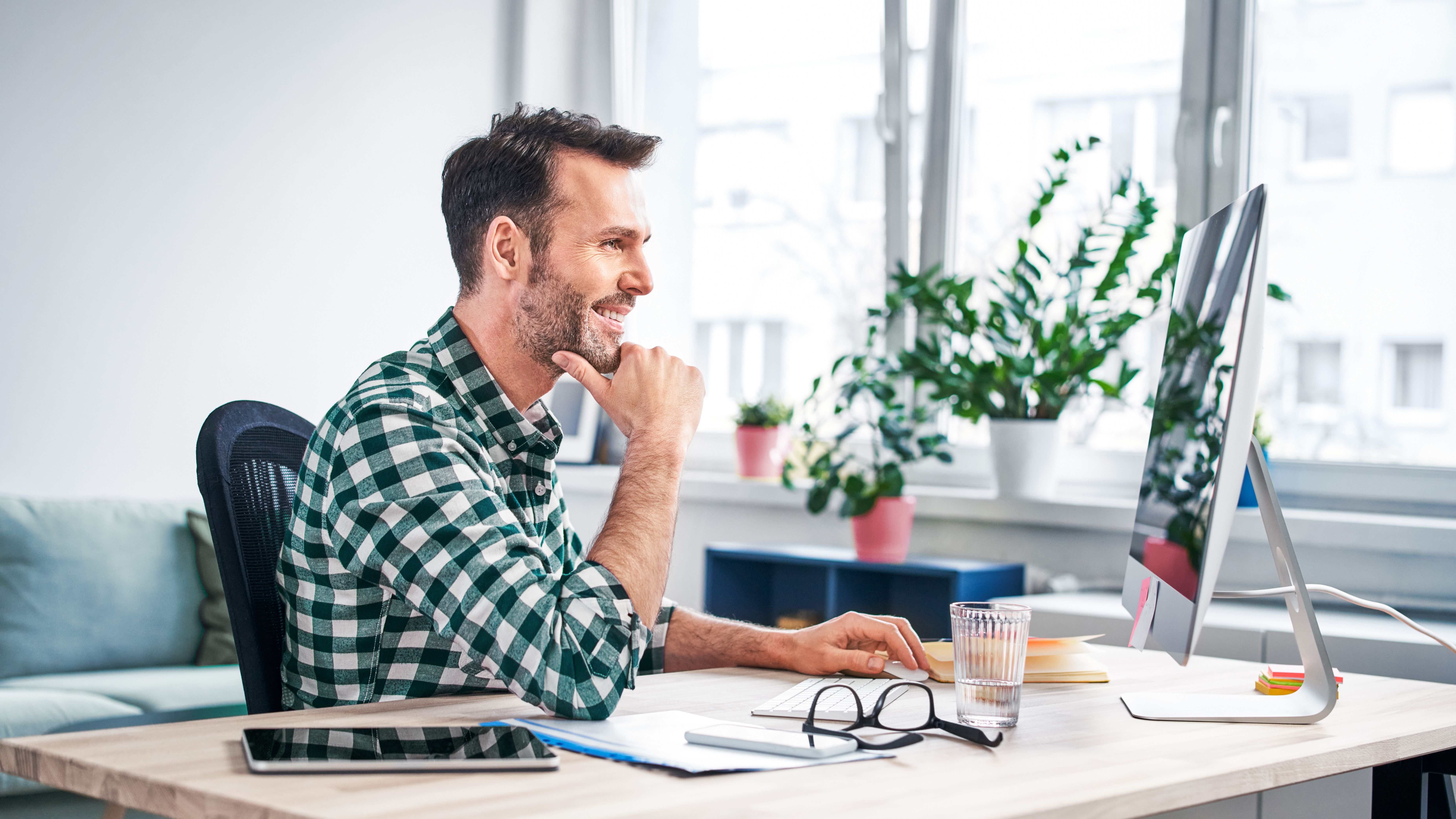 With web hosting from Green it's easy to have your own website Man in an office at his computer
