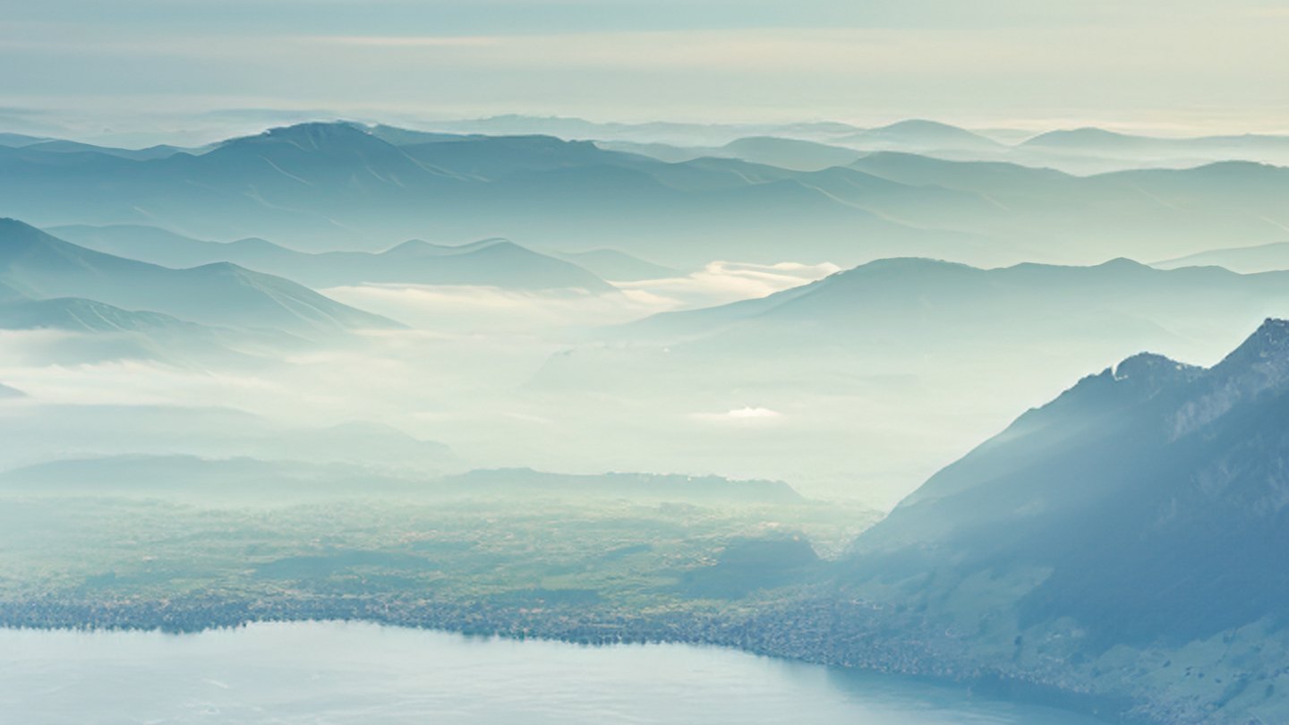 Far-reaching views over wooded hills with light wafts of mist