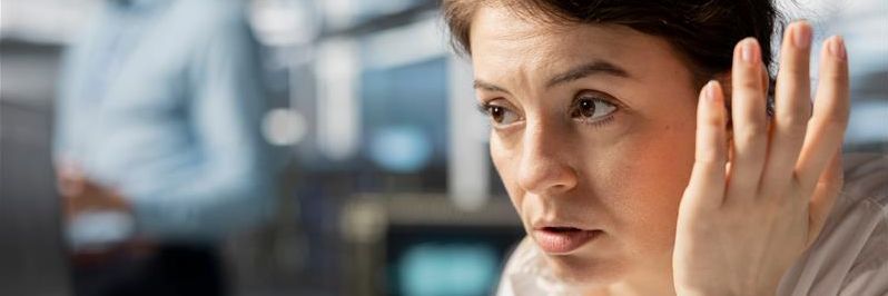 Besorgte Frau im Büro während eines Website-Ausfalls verdeutlicht die Wichtigkeit von zuverlässigem Hosting.