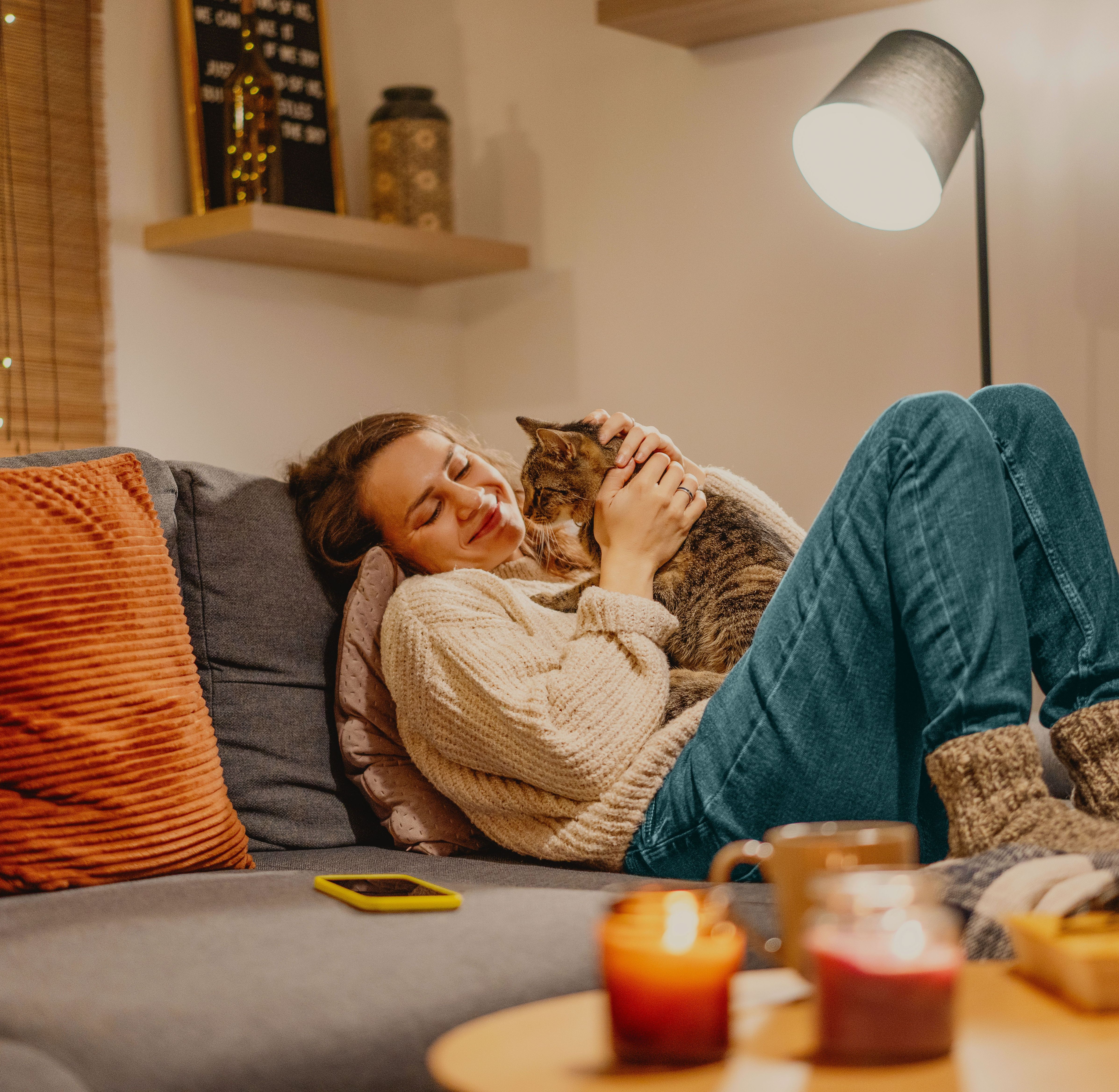 Jeune femme assise confortablement sur le canapé avec son chat.