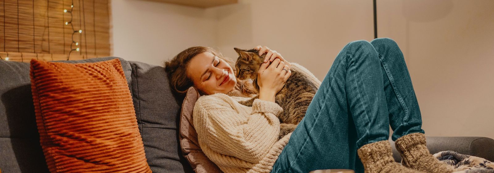 Jeune femme assise confortablement sur le canapé avec son chat.