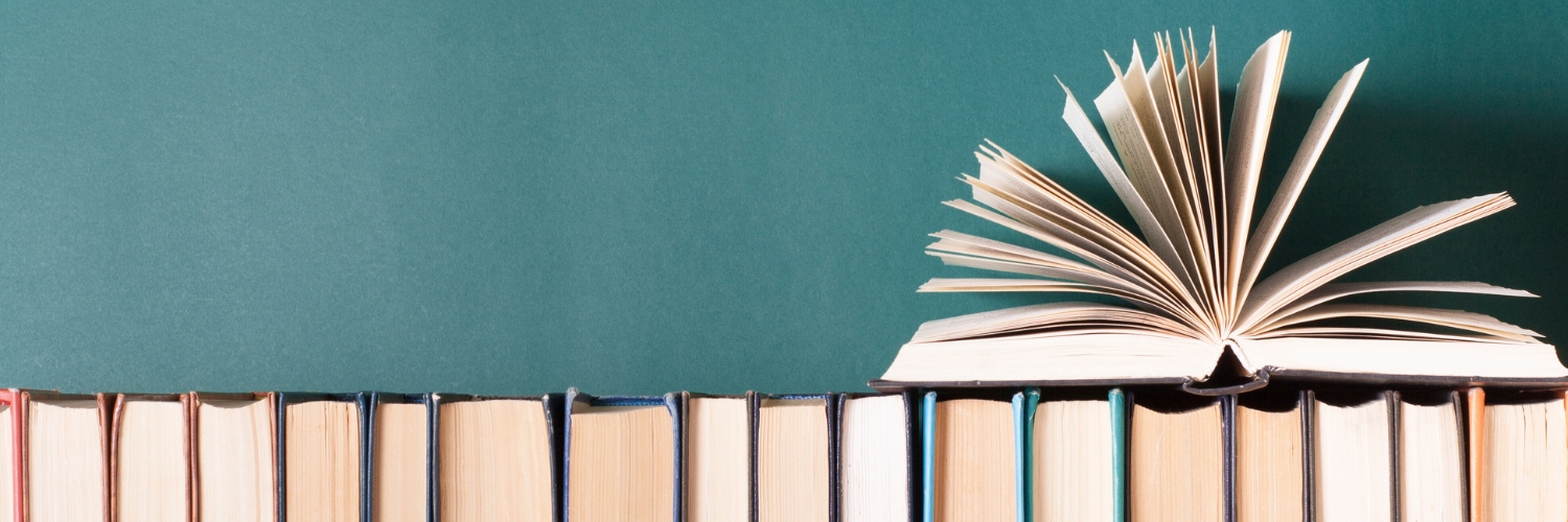 Offenes Buch auf einer Reihe von geschlossenen Büchern – symbolisiert den Unterschied zwischen Website, Webseite und Homepage.